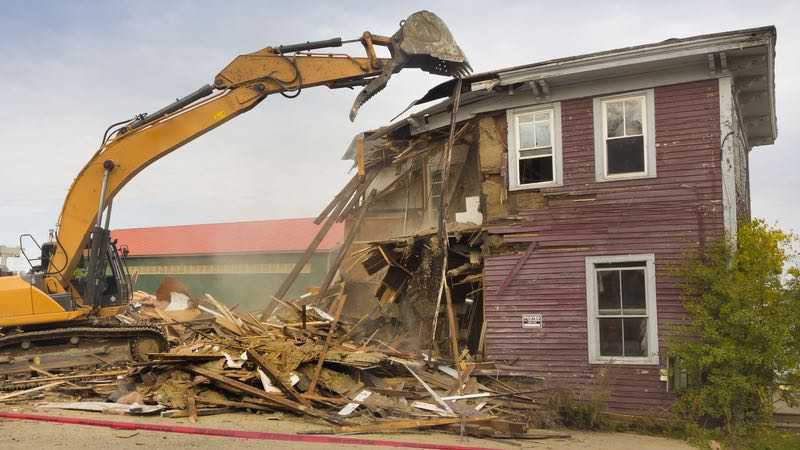 Bagger beim Rückbau eines Holzhauses