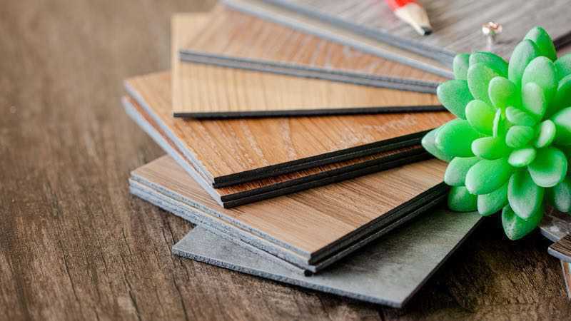 Vinyl-Fliesen Muster-Stapel auf Holztisch für Bodenbelagsarbeiten