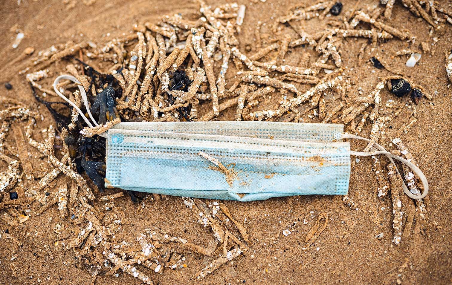 Weggeworfene Maske an einem Strand