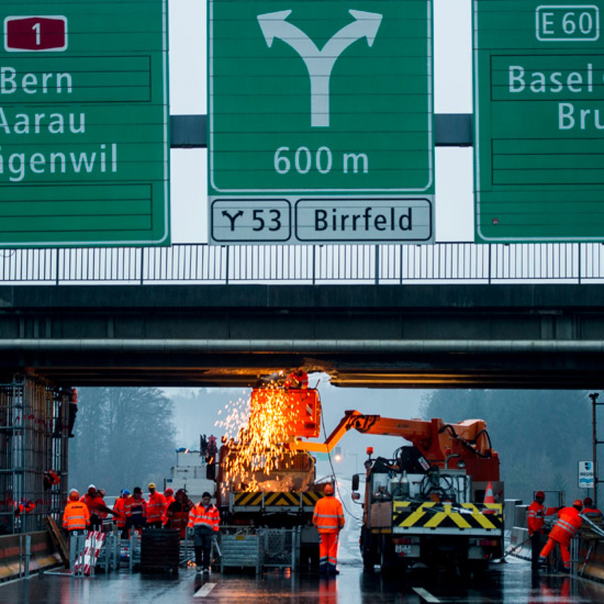 Arbeiter sichern die Bruecke nach einem Lastwagenunfall auf der A1 von Zuerich Richtung Bern/Basel, aufgenommen am Montag, 13. Januar 2014 in Birmenstorf AG. Ein mit einer Baumaschine beladener Anhaengerzug kollidierte in Fahrtrichtung Bern mit der Ueberf