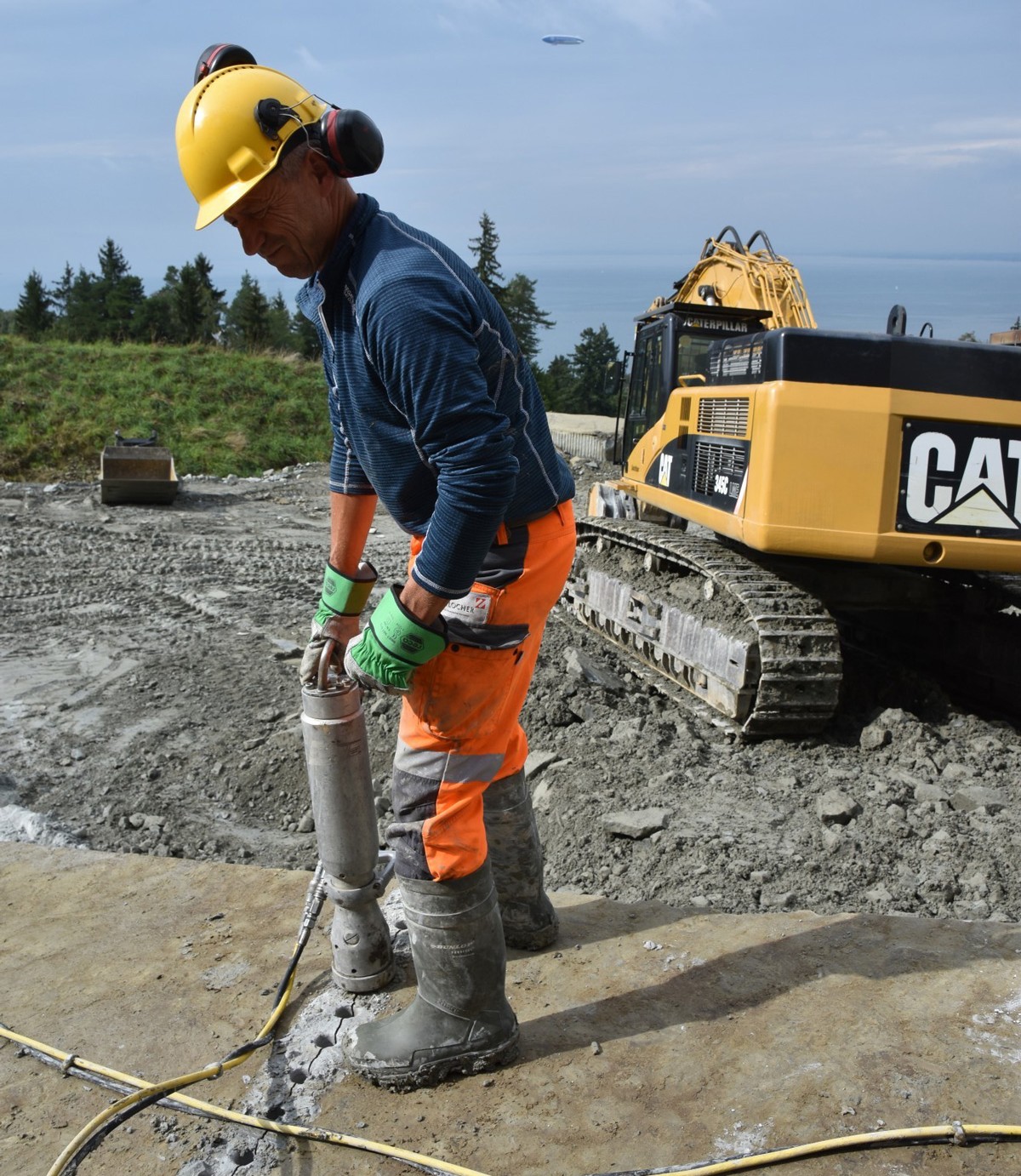 Steinquader werden mit Grossbagger Cat 320B plus Reihenbohrgerät angebohrt