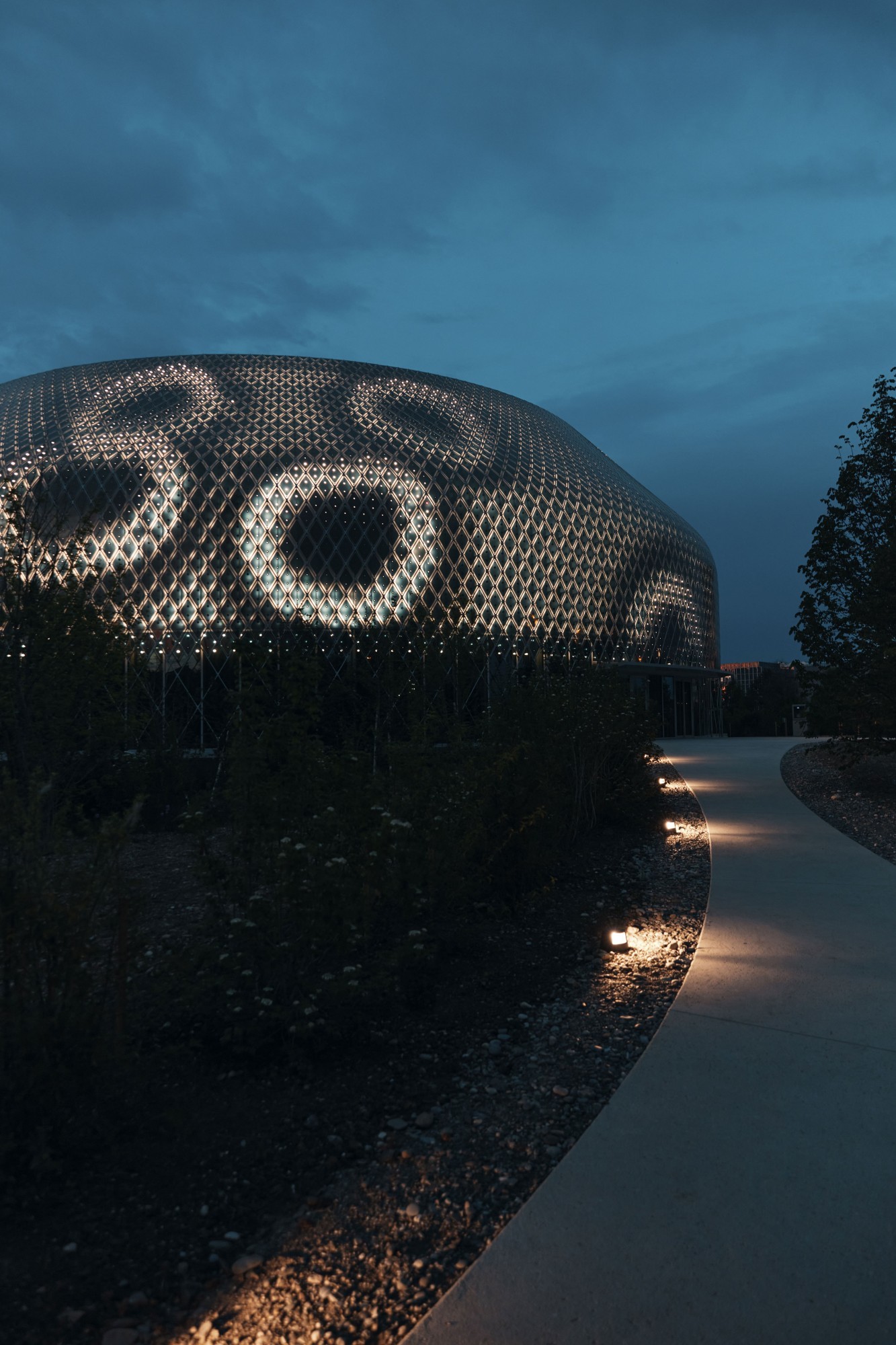 Pavillon auf dem Novartis-Campus, bei Nacht vom Boden aus gesehen.