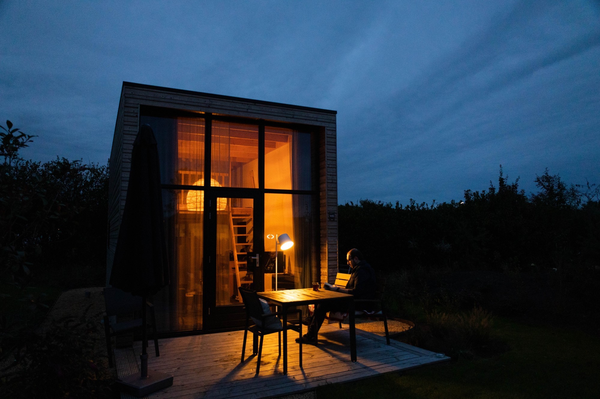 Tiny House mit Terrasse bei Nacht (Symbolbild)