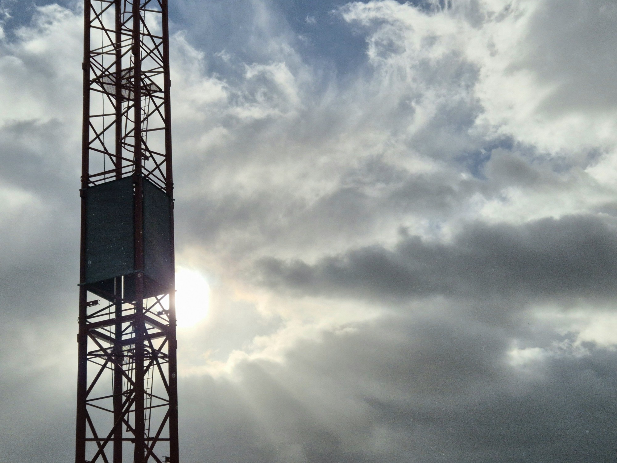 Kran vor bewölktem Himmel im Gegenlicht