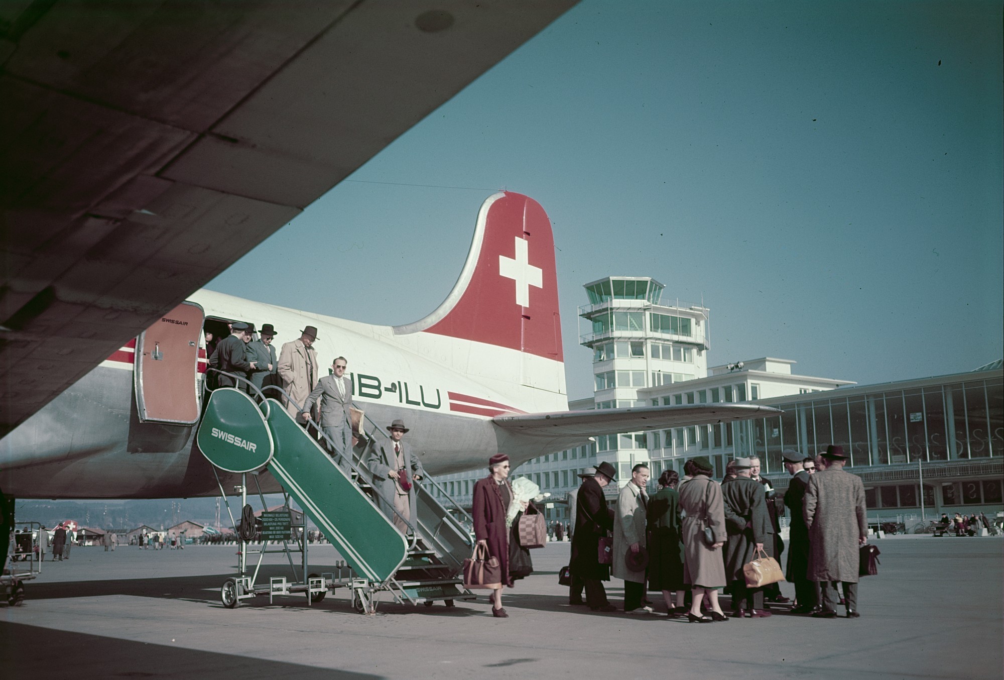 Flugpassagiere verlassen eine Douglas C54E-5-DO (DC-4) HB-LU auf dem Flughafen Zürich-Kloten.