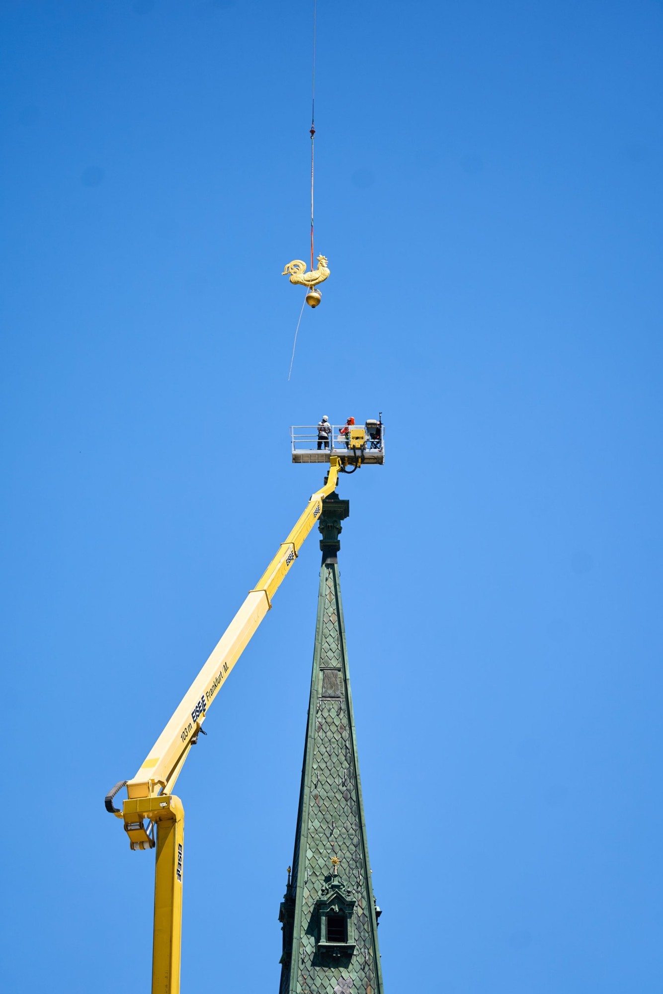 Der Wetterhahn schwebt am Helikopterseil zur Kirchturmspitze