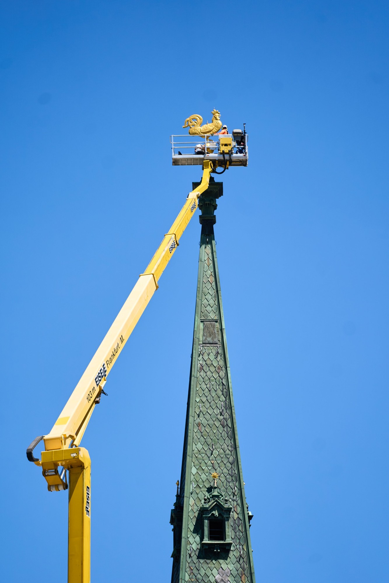 Aus dem Arbeitskorb wird der Wetterhahn an seiner Position montiert