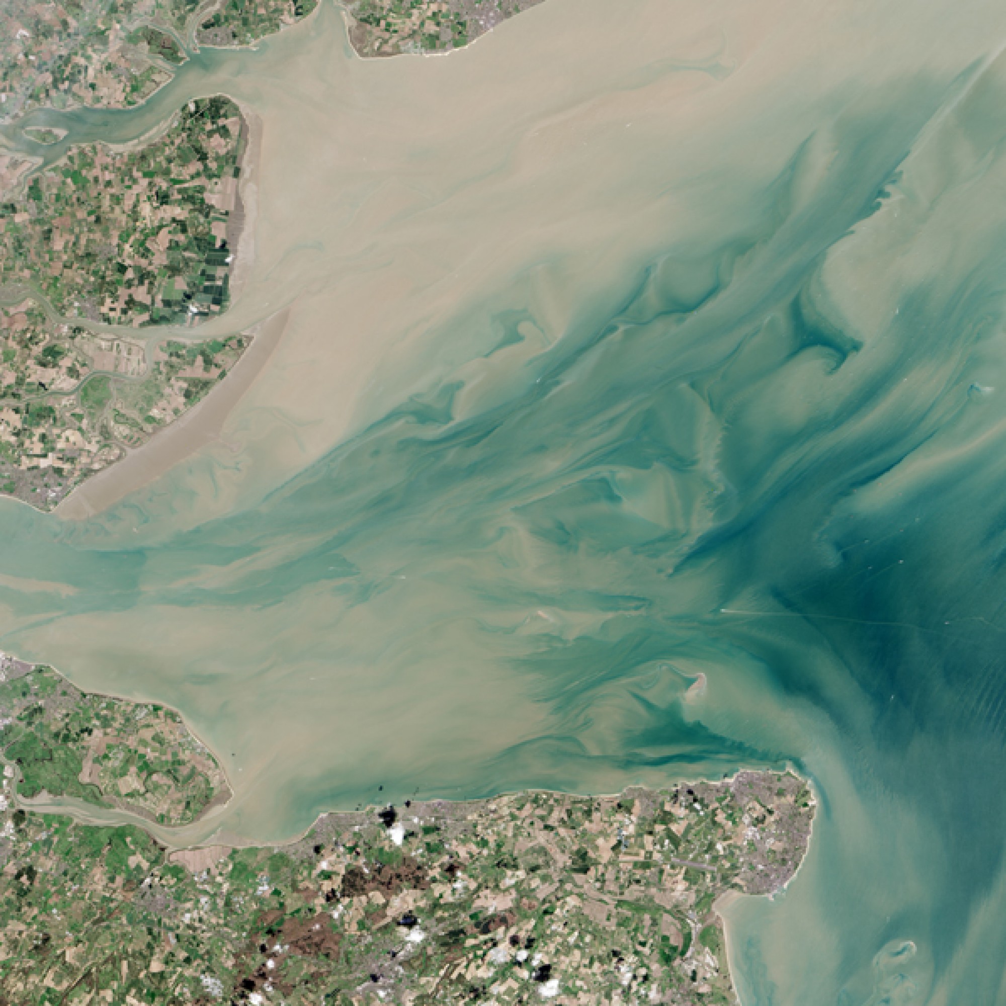 Und vor der Küste Englands, bei der Themsemündung schimmern Land und Wasser in Pastelltönen. (Nasa)