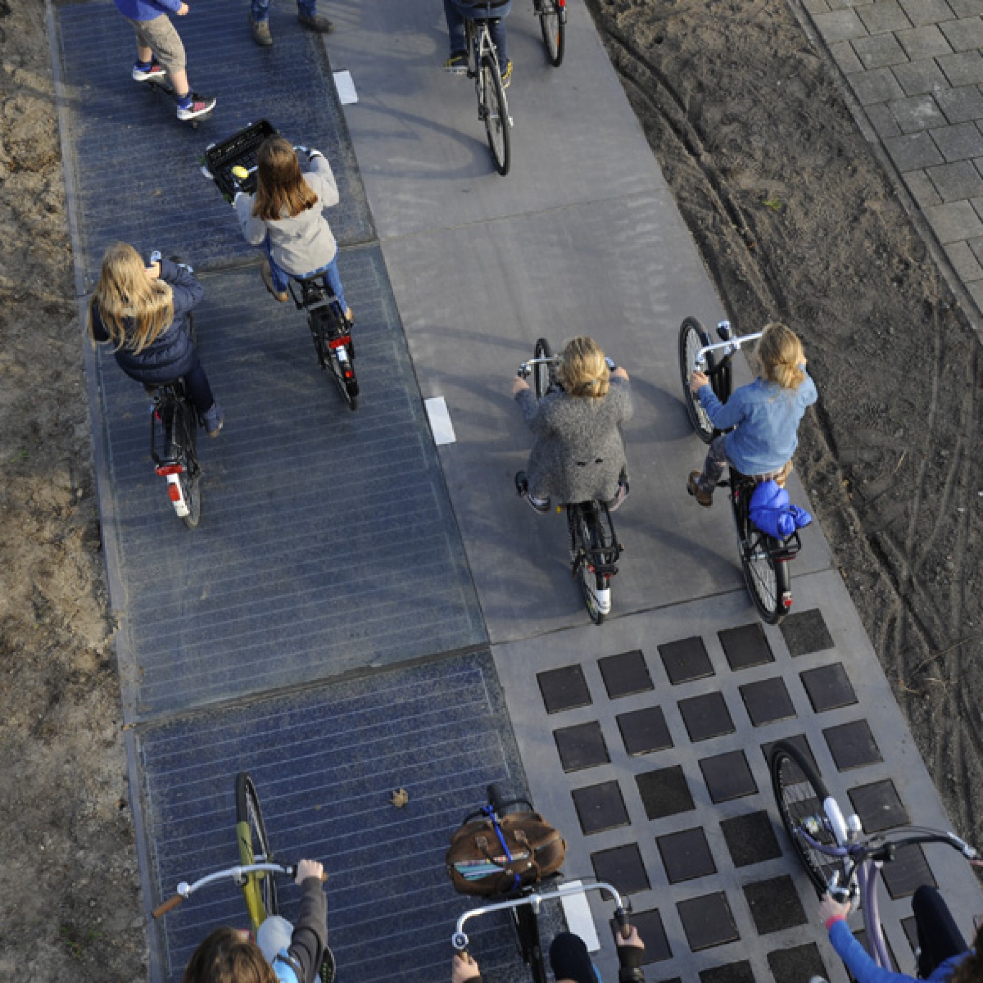 Die Velofahrer merken kaum einen Unterschied, wenn sie über die mit Solarpanels bedeckte Fahrbahn (links) fahren. (Bild: zvg)