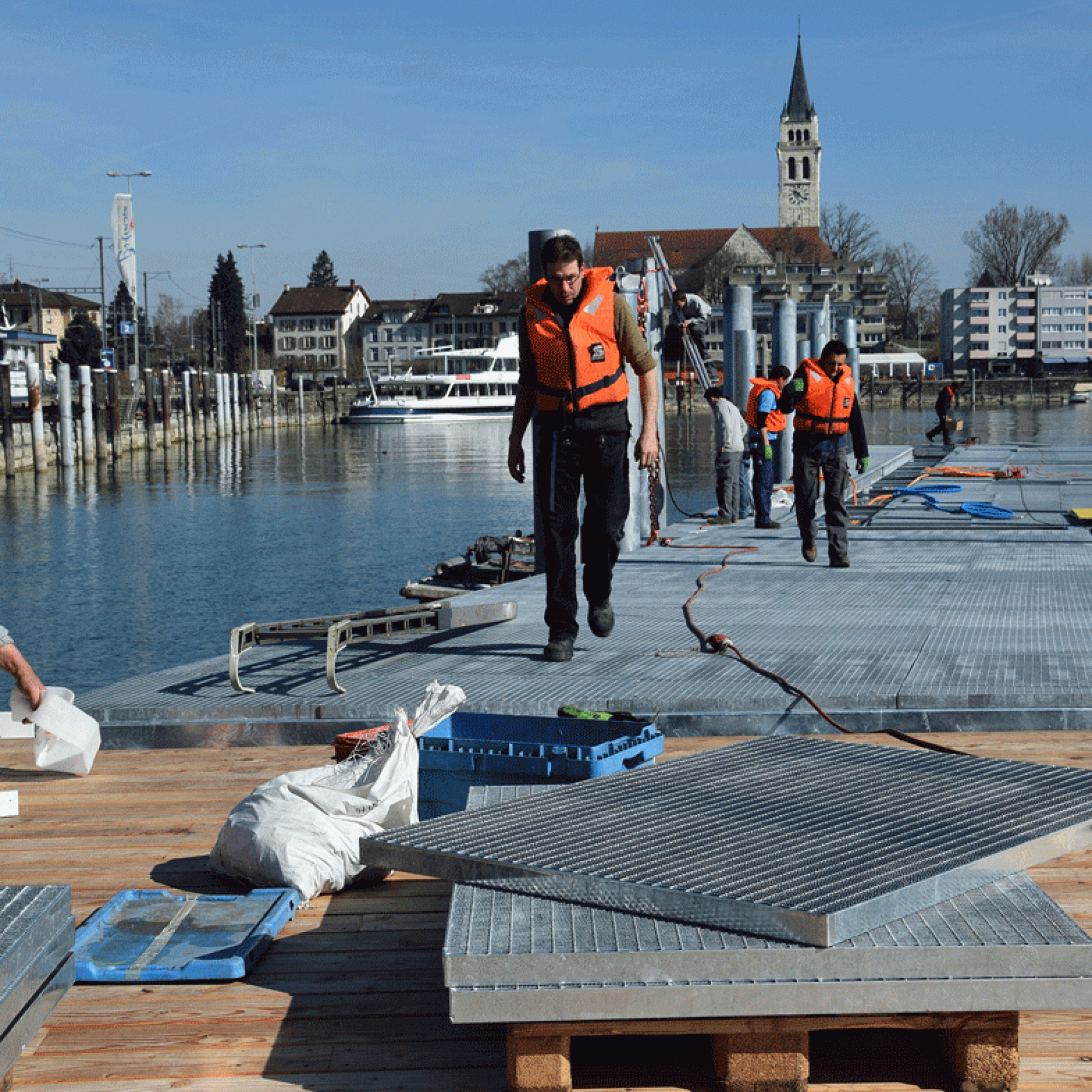 Die Gitterroste werden auf den Schwimmstegen im Romanshorner Hafenbecken platziert.