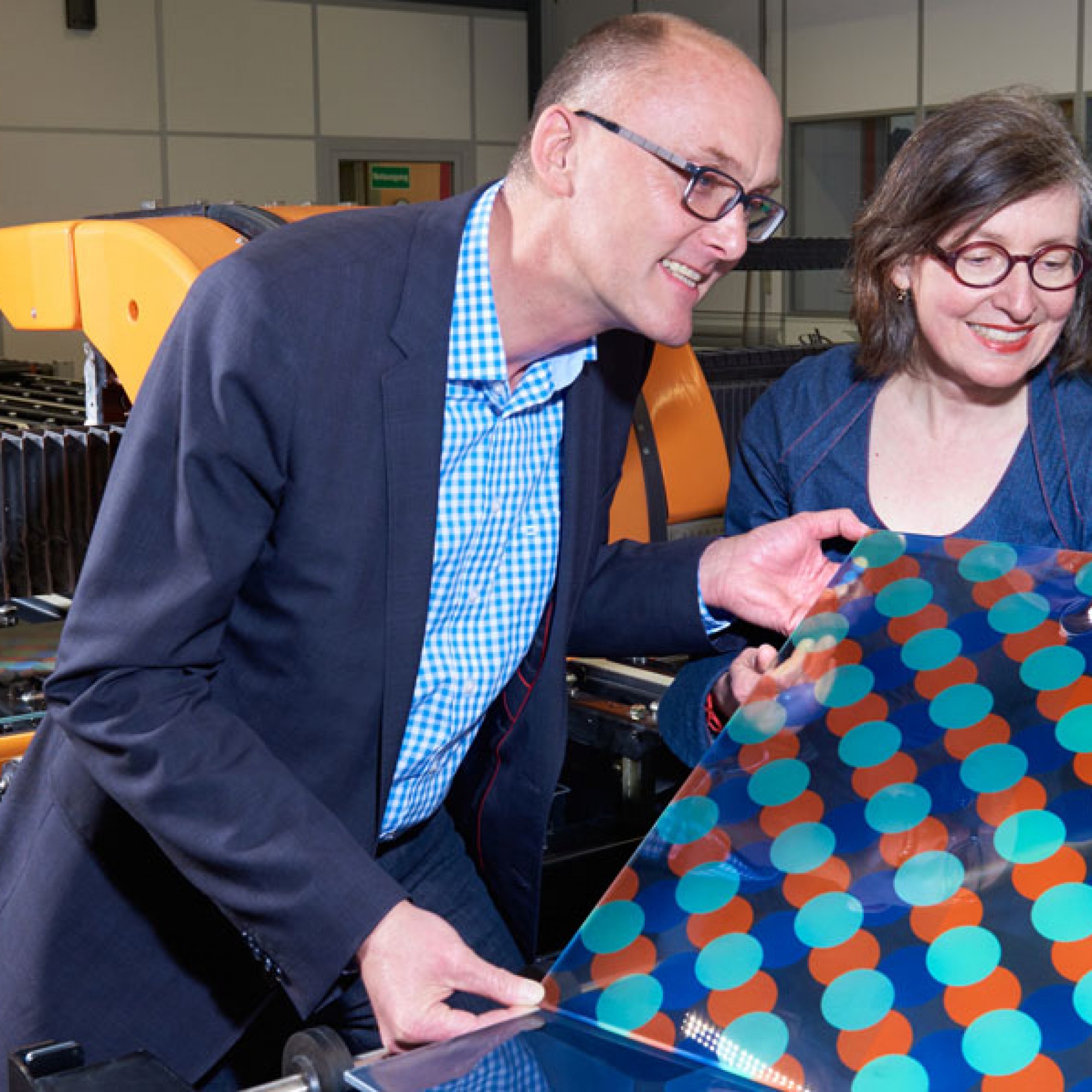 Monika Gold und Stephen Wittkopf von der Hochschule Luzern verfolgen den Druck eines Musters bei der Glas Trösch AG. (Doris Kuert/HSLU)