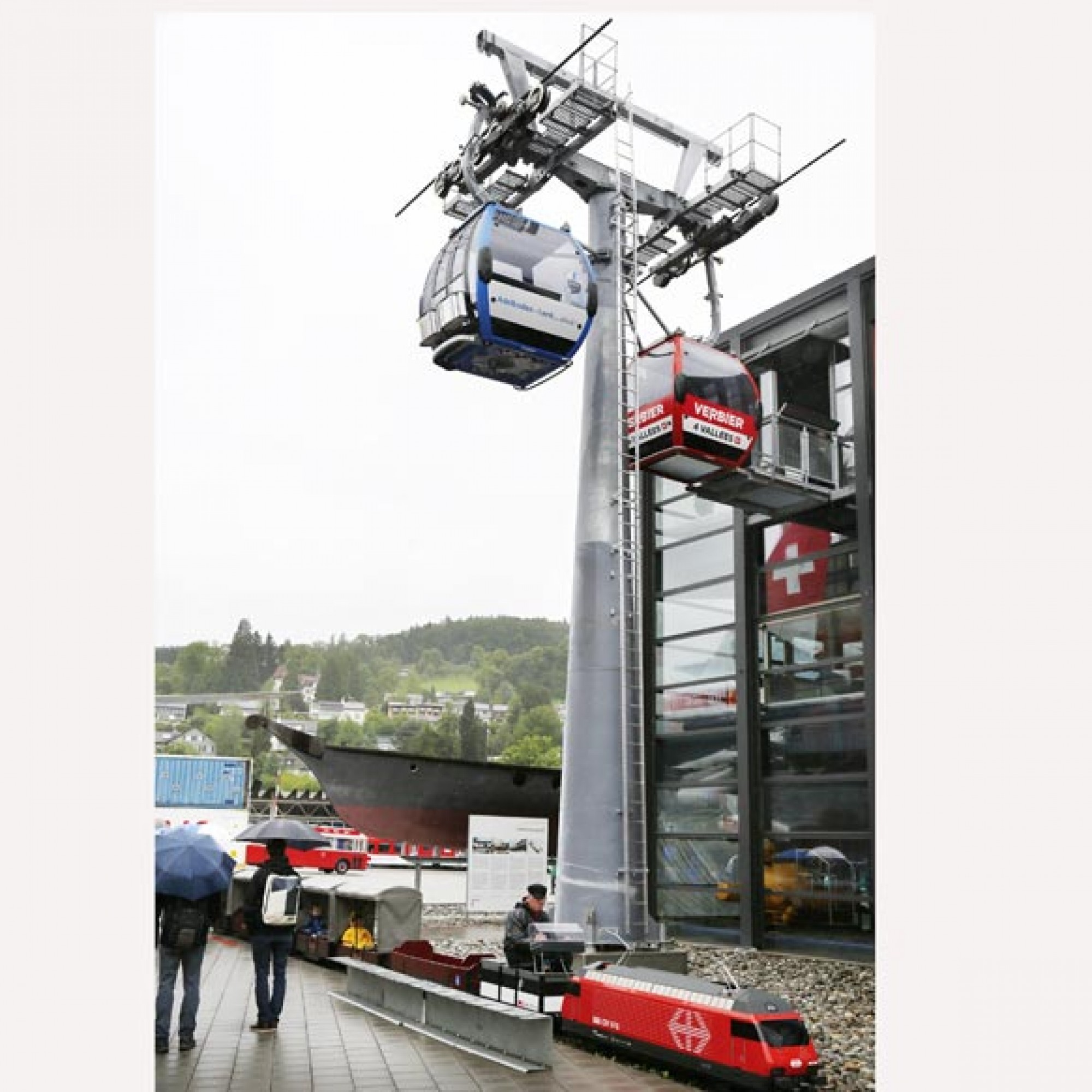 Vor der Halle Seilbahnen und Tourismus steht ein Original-Seilbahnmast mit zwei  Gondeln. (Foto: Verkehrshaus der Schweiz/Christen)