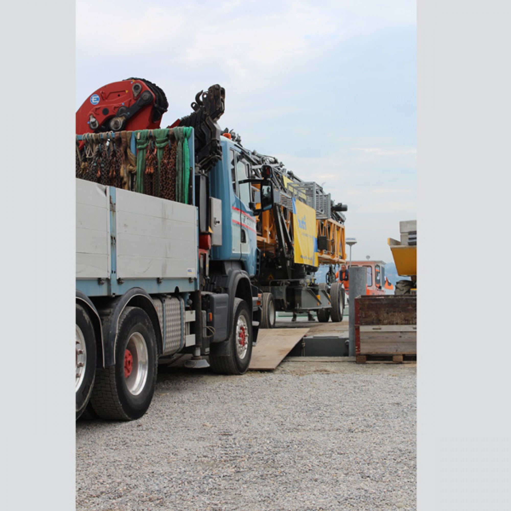 Ein LKW schiebt das tonnenschwere Baugerät auf den Ponton.