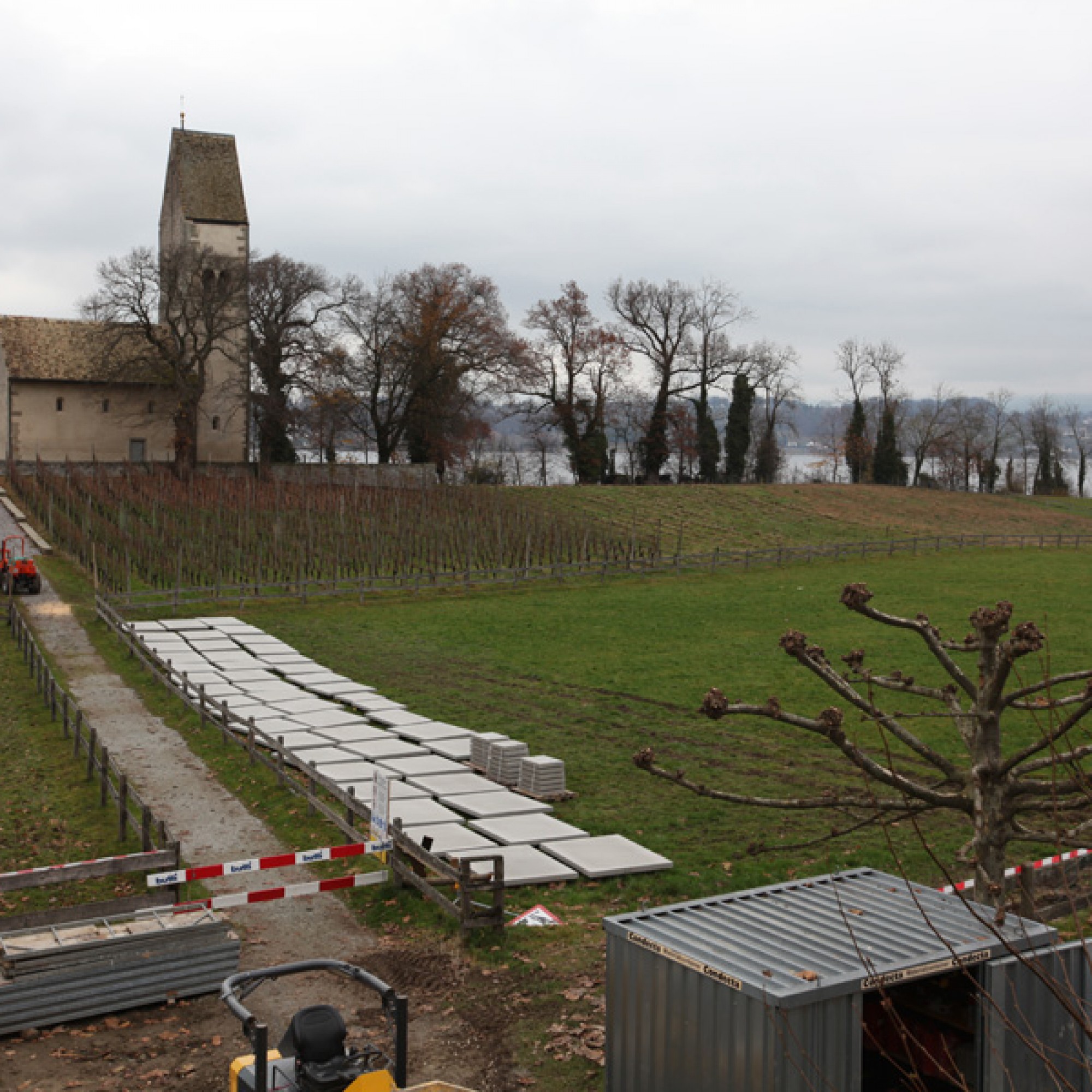 Blick vom Dach des Hauses „Zu den zwei Raben“ auf die Kirche St. Peter und Paul: Da auf dieser Baustelle viel Platz zur Verfügung steht, werden die für die Umgebungsgestaltung vorgesehenen Steinplatten draussen gelagert und erhalten bis zu ihrem Einsatz b
