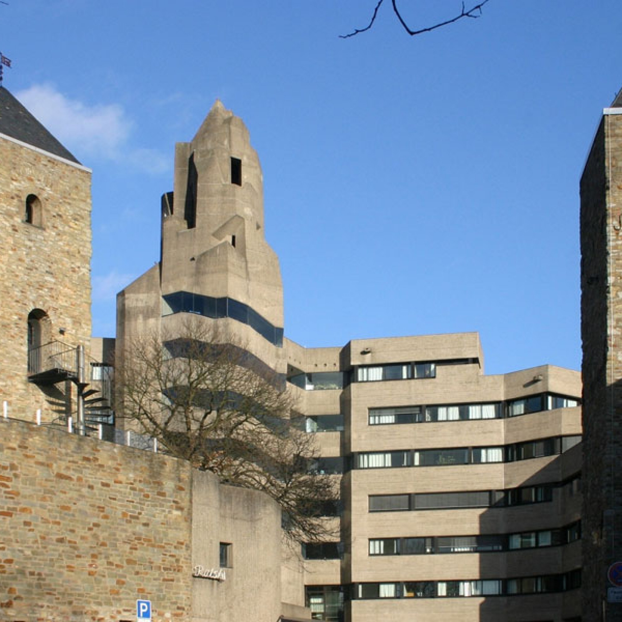 Das in Sichtbeton gestaltete Bensberger Rathaus im Deutschen Bergisch Gladbach wurde Ende der 60er-Jahre in die mittelalterliche Burganlage des Alten Schloss Bensberg integriert. (Bild: Grkauls)