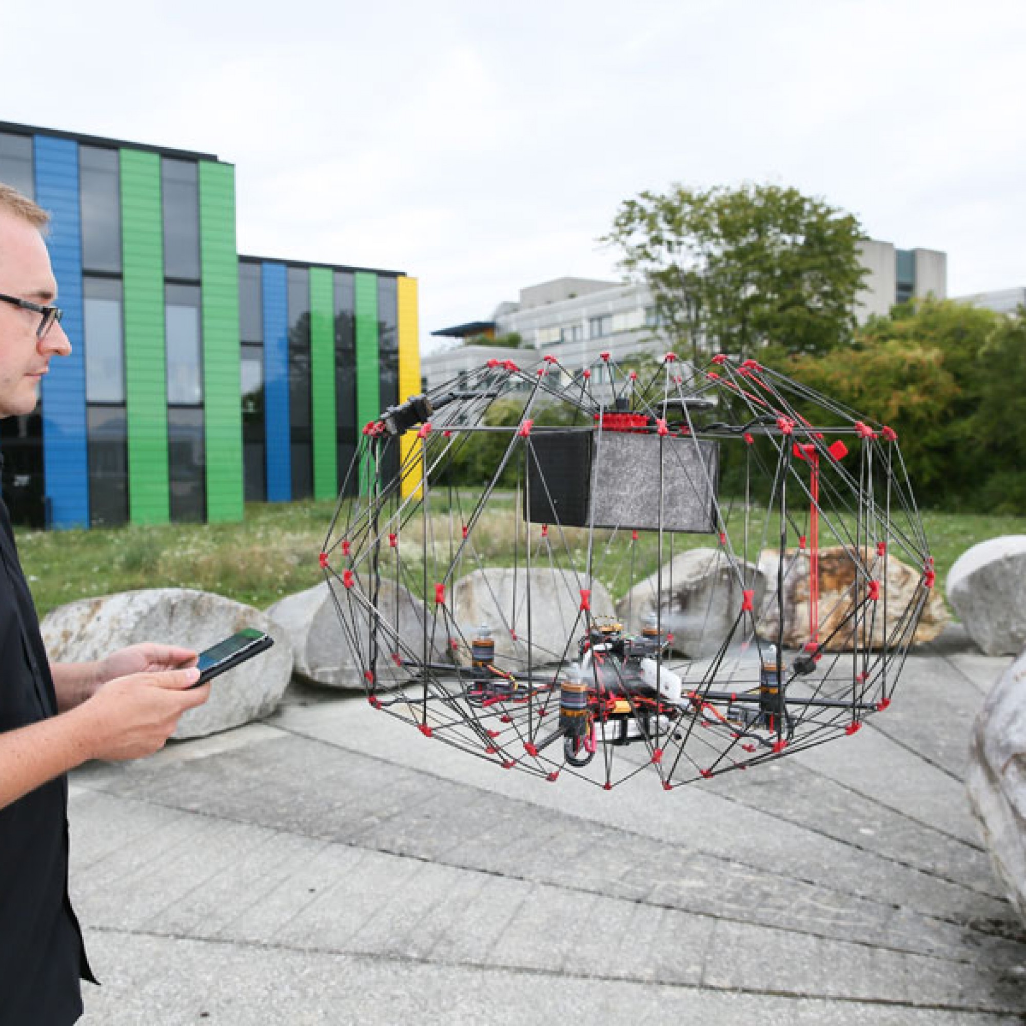 Die Drohne kann auch im Flug gefangen werden, der Schutzkäfig schützt den Empfänger vor den Propellern. (Bild: EPFL)