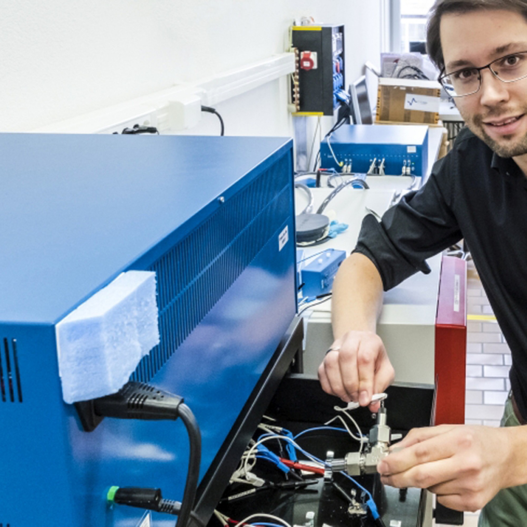 Forschung am Wasser-Elektrolyt: Empa-Forscher Ruben-Simon Kühnel schliesst eine Test-Zelle mit der konzentrierten Salzlösung ans Ladegerät an. In mehreren Lade- und Endladezyklen wird die Stabilität des Systems ermittelt.