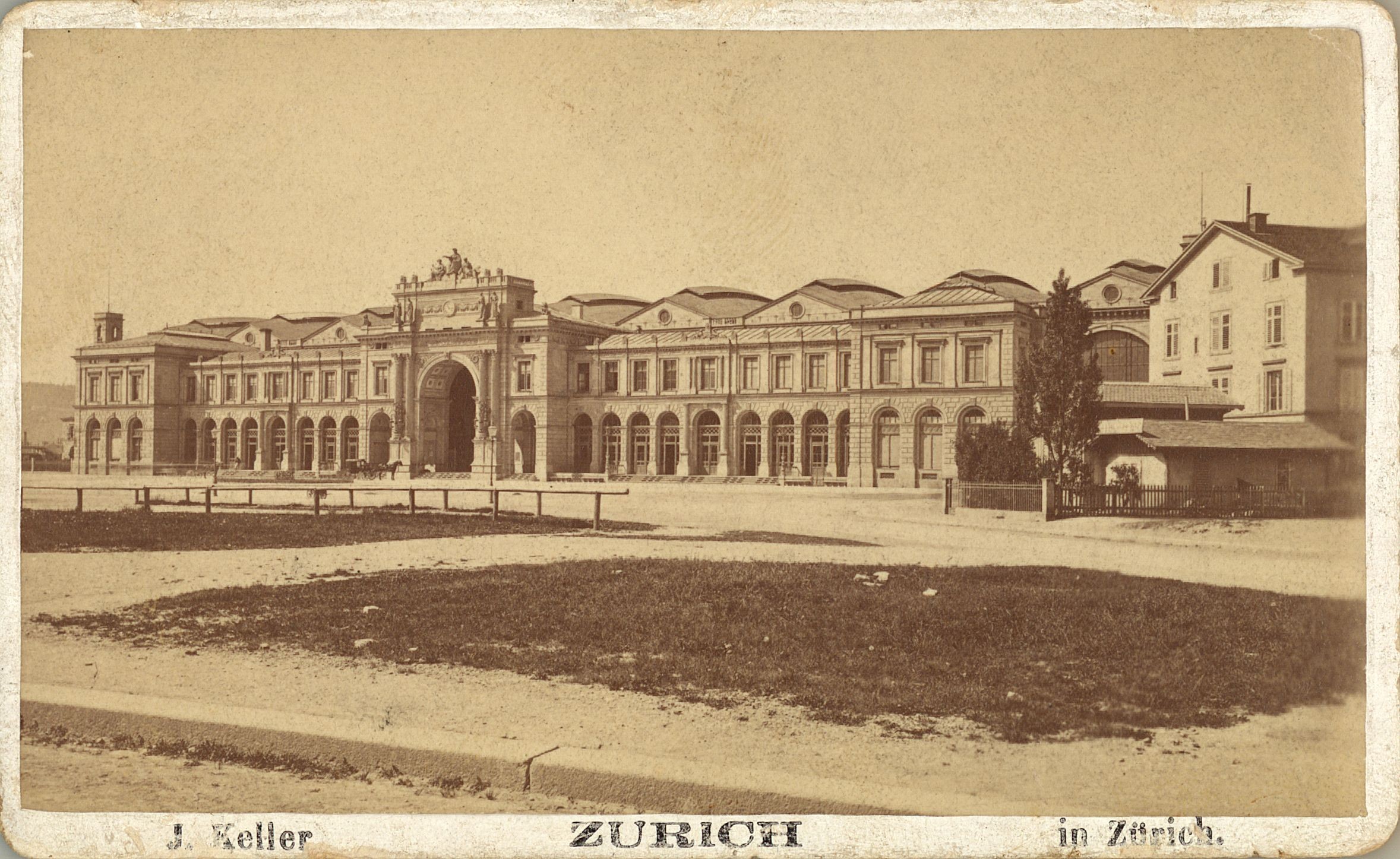 Zwischen 1870 und 1880 sieht der Bahnhofplatz ein wenig leer und trostlos aus. Noch fehlen das Alfred-Escher-Denkmal und der Brunnen, die Jahre später den Platz prägen sollten.