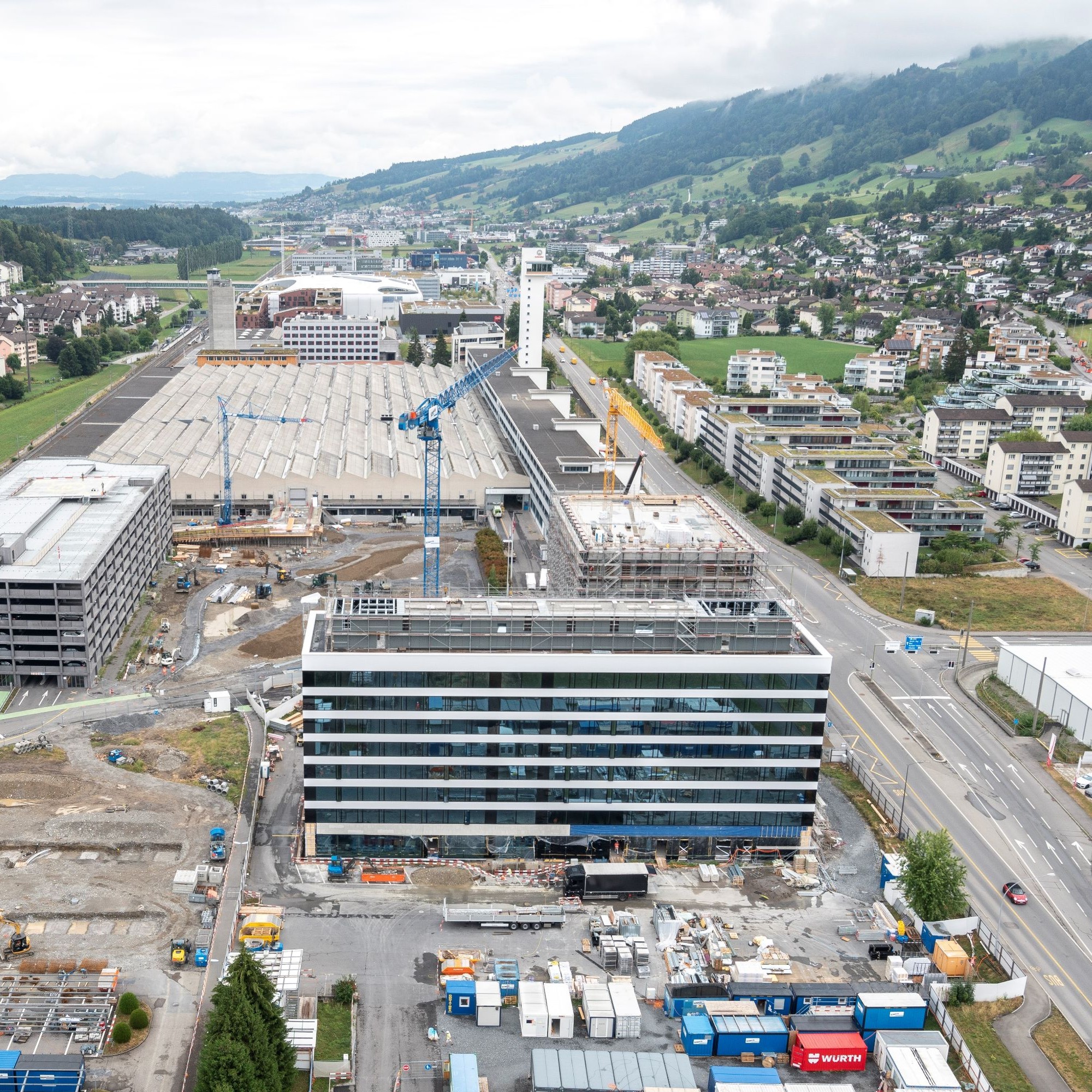Luftaufnahme vom Schindler Campus und Rontal: Baustelle mit dem Management-Gebäude im Vordergrund. Im Hintergrund die Produktionshalle und der Testturm.