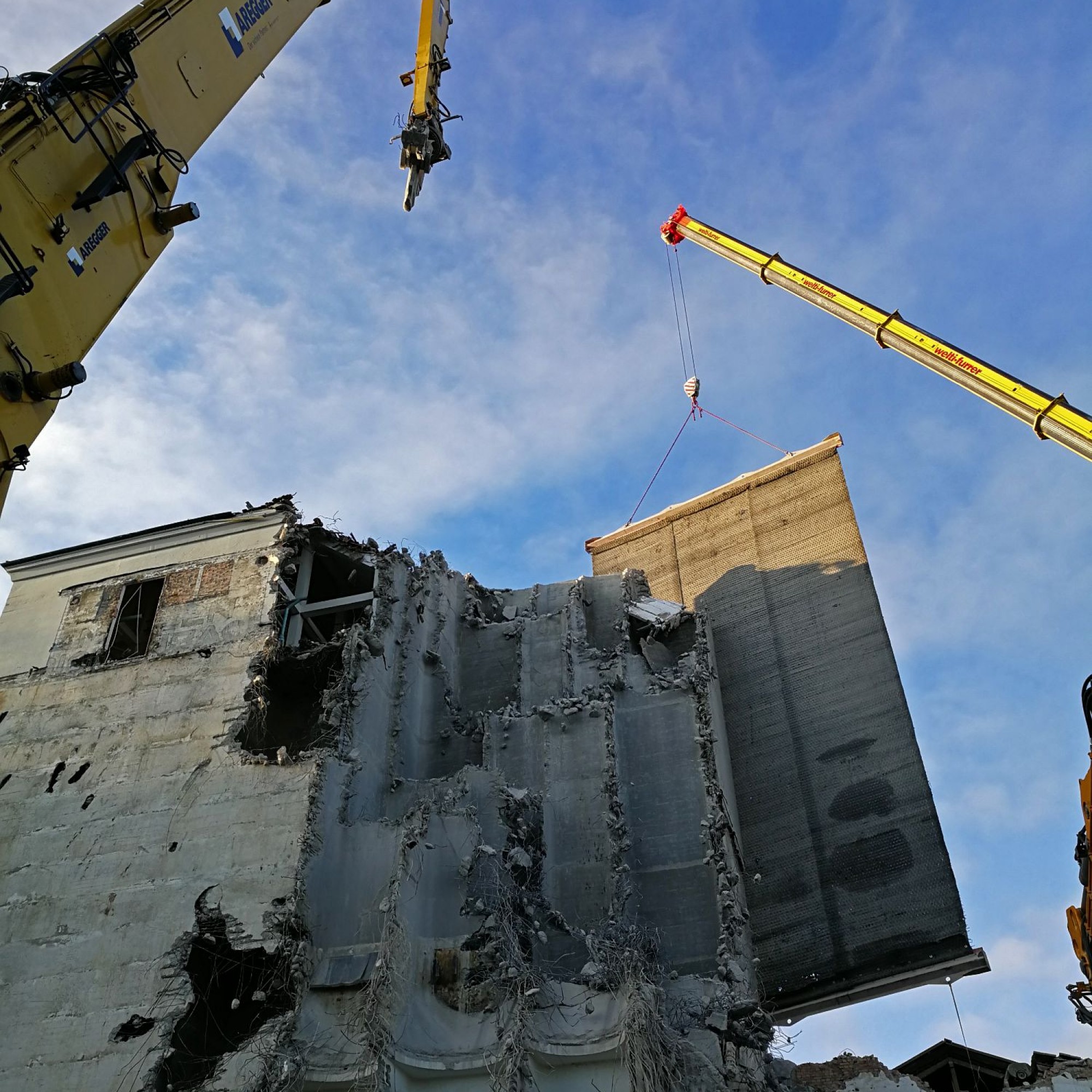 Die vorgehängte Gummimatte verhindert, dass beim Abbruch das angrenzende Mühlhaus beschädigt wird. 