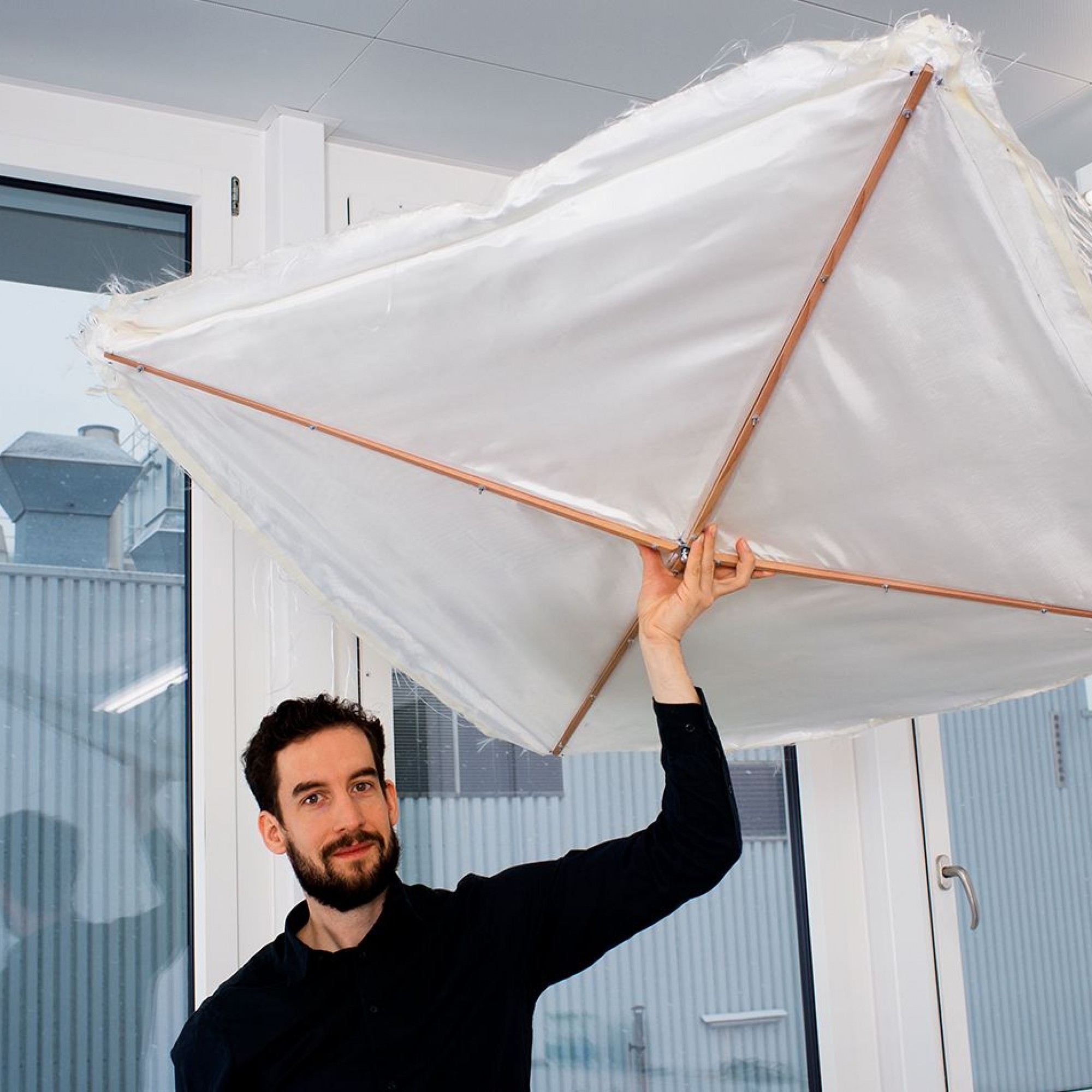 Daniel Wehrli von der Forschungsgruppe Produkt und Textil der Hochschule Luzern (HSLU) präsentiert ein Modell des textilen Dämmelements «Schirm».