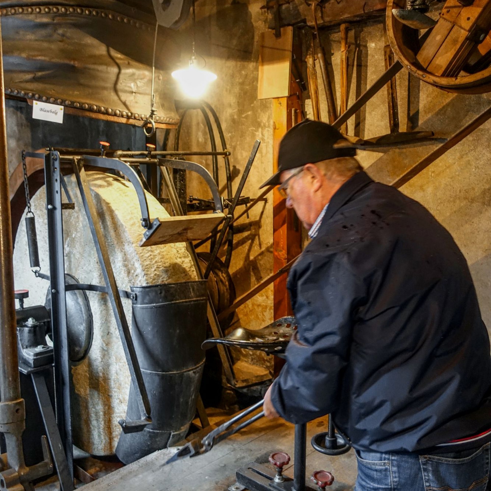Jörg Leimgruber setzt das Wasserrad des Balghauses in Betrieb, das den Schleifstein und den darüberhängenden Blasbalg für das Anheizen der Esse in der Schmiede antreibt. 