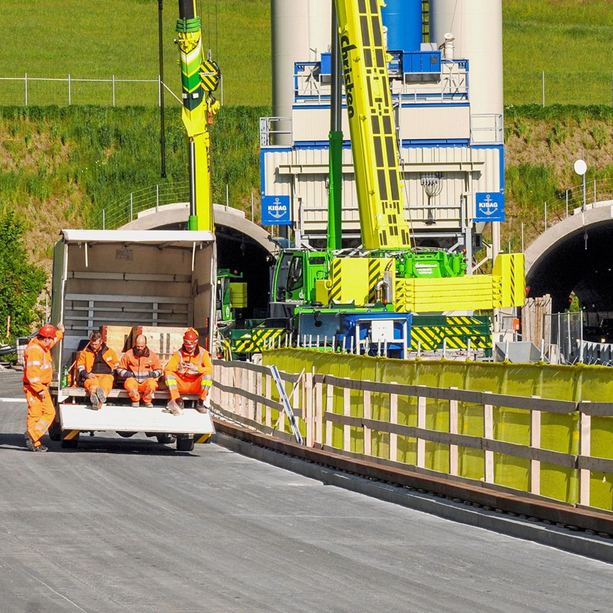 Znünipause der Arbeiter auf der UHFB-Schicht, die ohne Abdichtung verbaut wird und nur noch eine Deckschicht aus Gussasphalt benötigt. Im Hintergrund die eigens für die Baustelle konzipierte Betonmischanlage der Kibag.