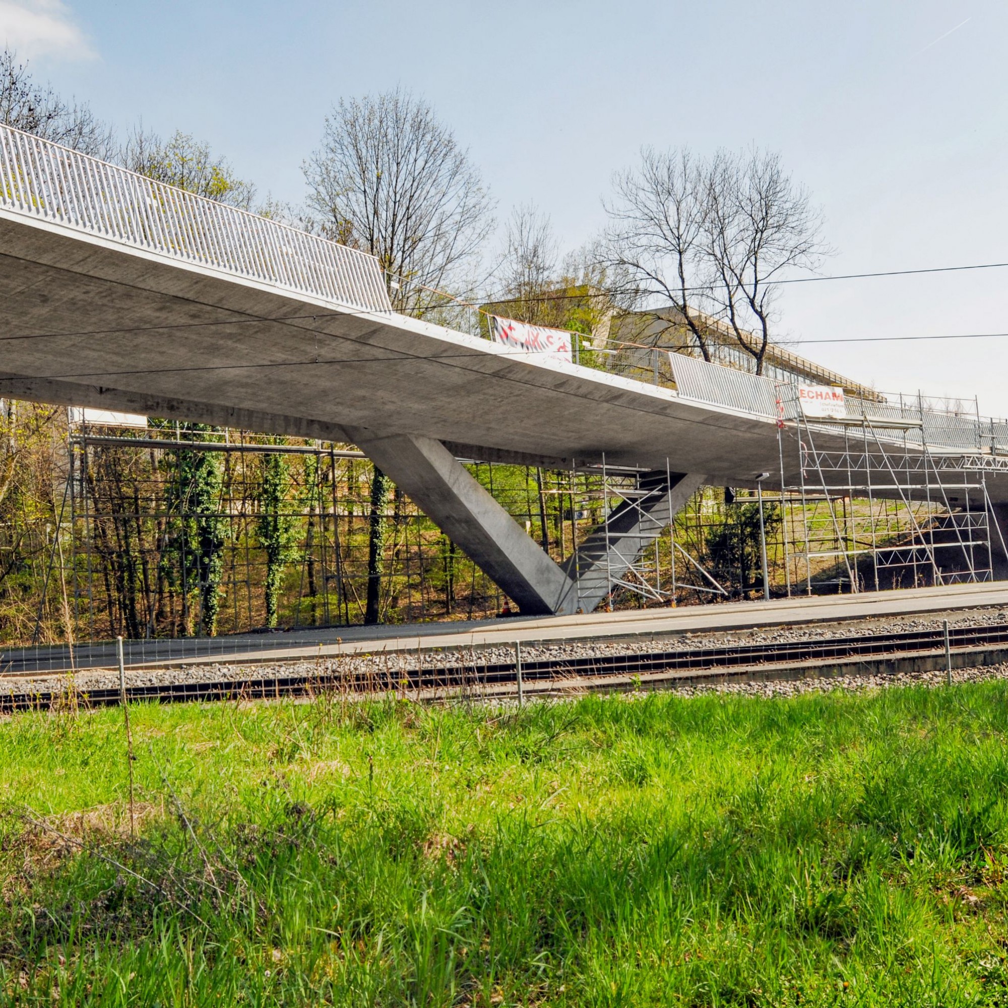 Zum Bauprojekt gehört auch die Brücke, über welche Fahrzeuge und Fussgänger das Gebäude erreichen und welche die Gleise der Lausanner Métro überspannt.