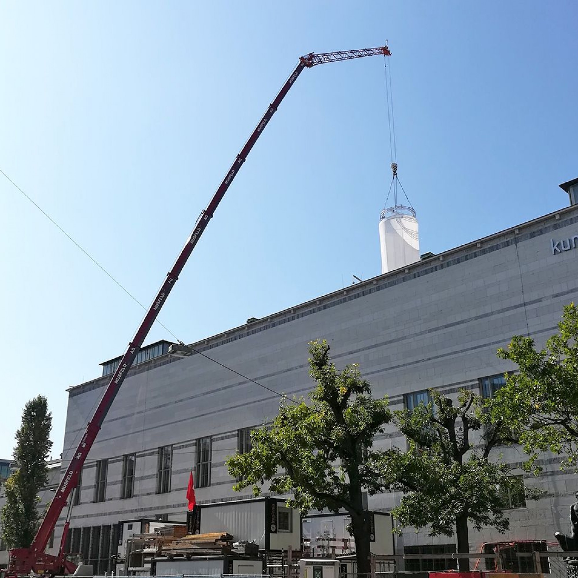 Der Kran in einer Seitenstrasse richtet die Stoffröhre über das Dach des Kunstmuseums hinweg auf. Bei starkem Wind muss sie eingefahren werden.