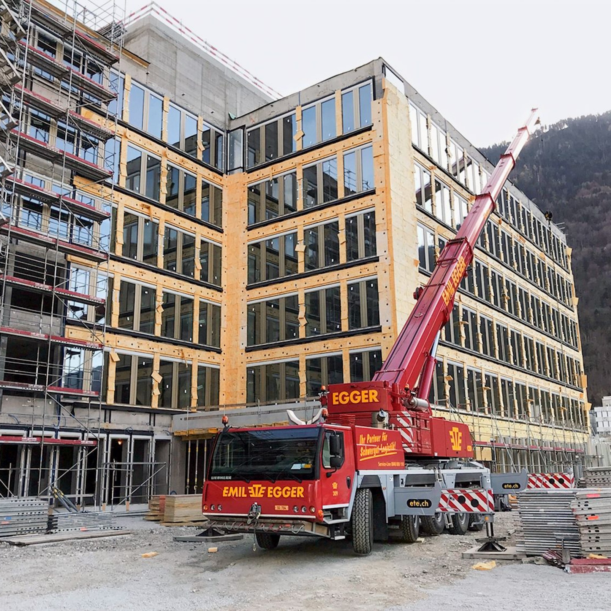 Montage der Fassadenisolation: «Sinergia» ist an ein Anergienetz angeschlossen und wird trotz der strengen Bündner Winter verhältnismässig wenig Heizenergie benötigen.