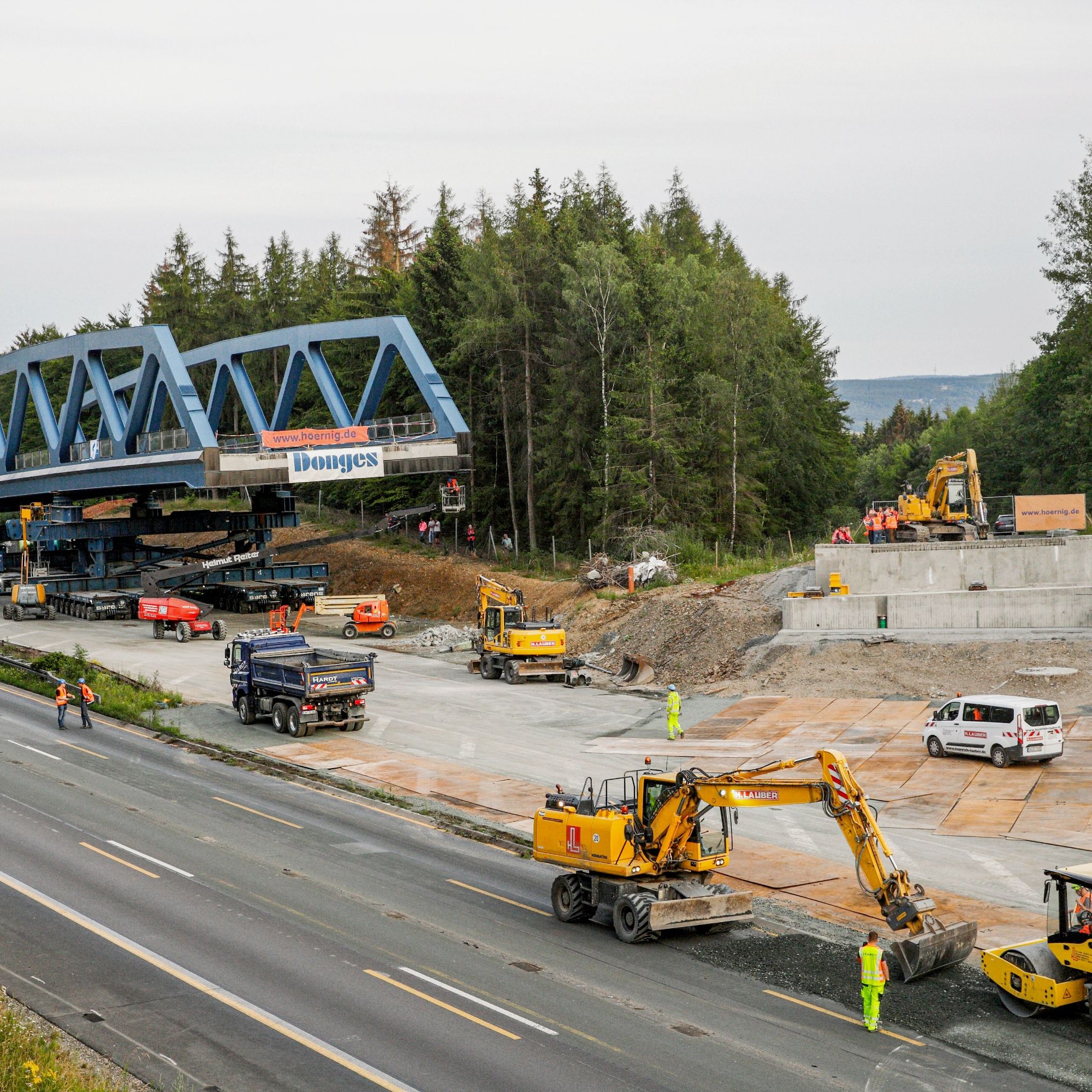 Die nördliche Brücke am Tag vor ihrer Einfahrt. Zu diesem Zeitpunkt waren die temporären Auflager bereits entfernt und die Brücke ruhte bereits auf den SPMT. Auch war sie mit hydraulischen Pressen knapp oberhalb ihrer künftigen Einbauhöhe angehoben. So wu