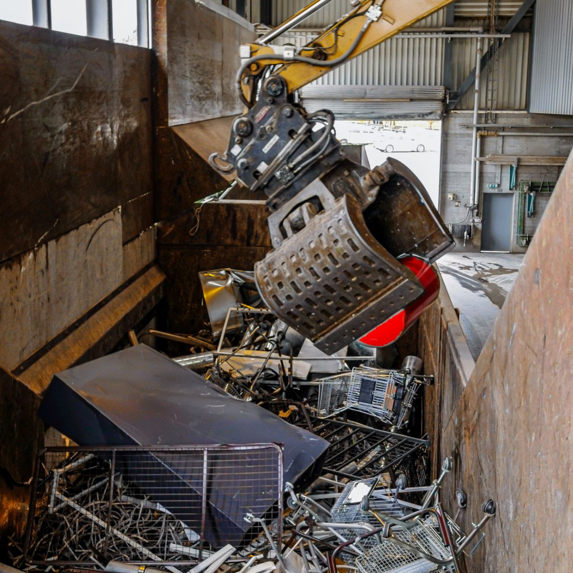 Ordnung in der Mulde: Ein weiterer Spezialbagger presst das Altmetall unter ohrenbetäubendem Getöse zusammen, um Platz für eine neue Ladung zu schaffen.