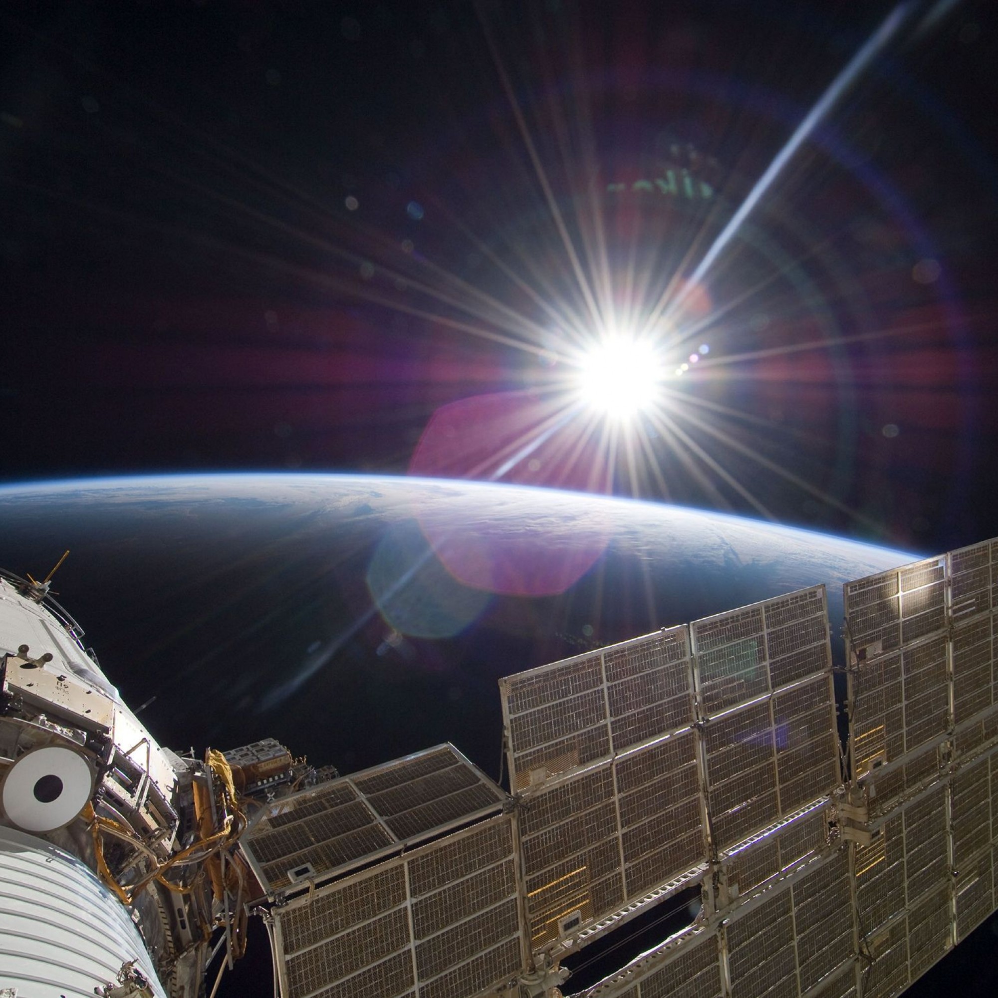 ISS über der Erde mit Sonne.