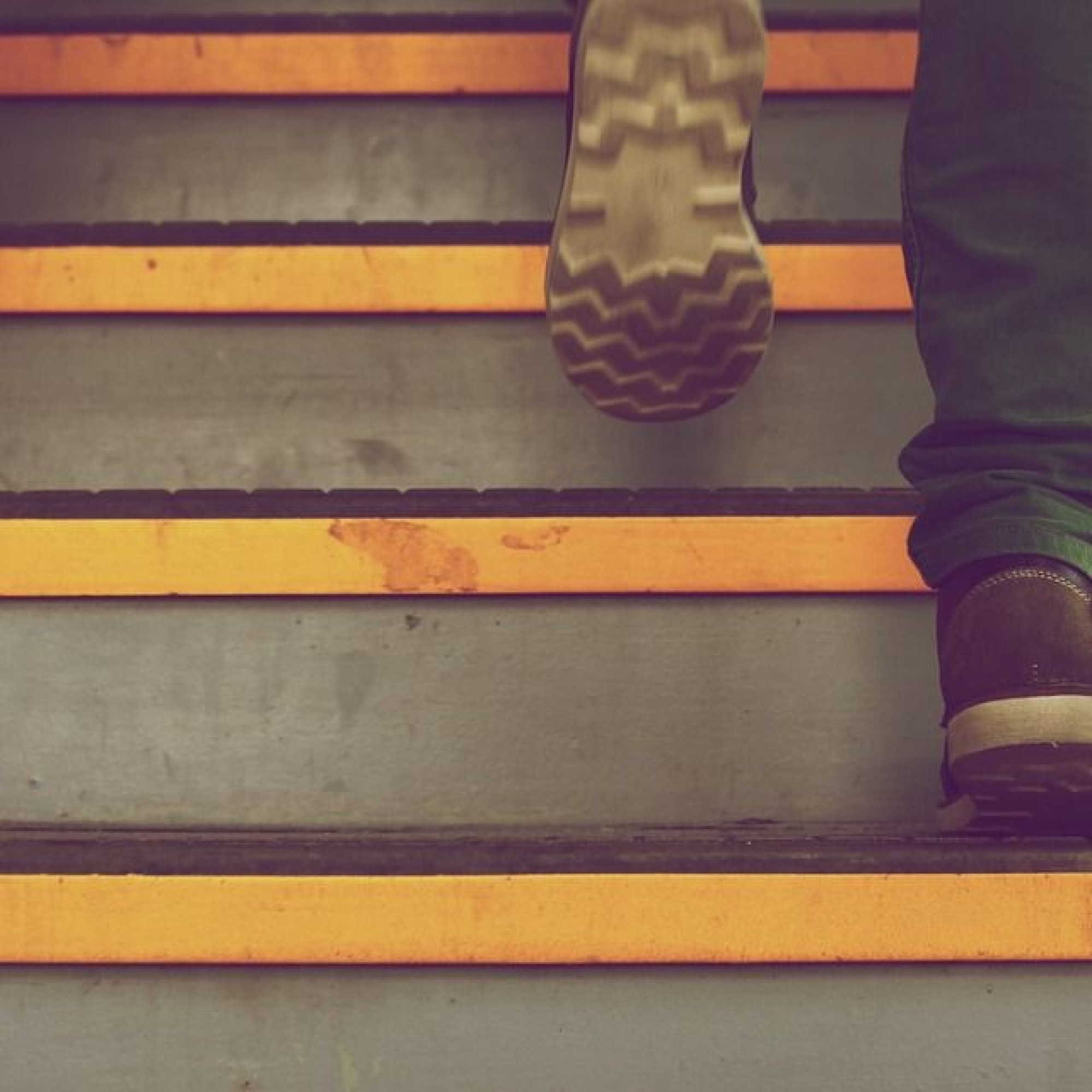 Mann mit Schuhen steigt Treppe hinauf