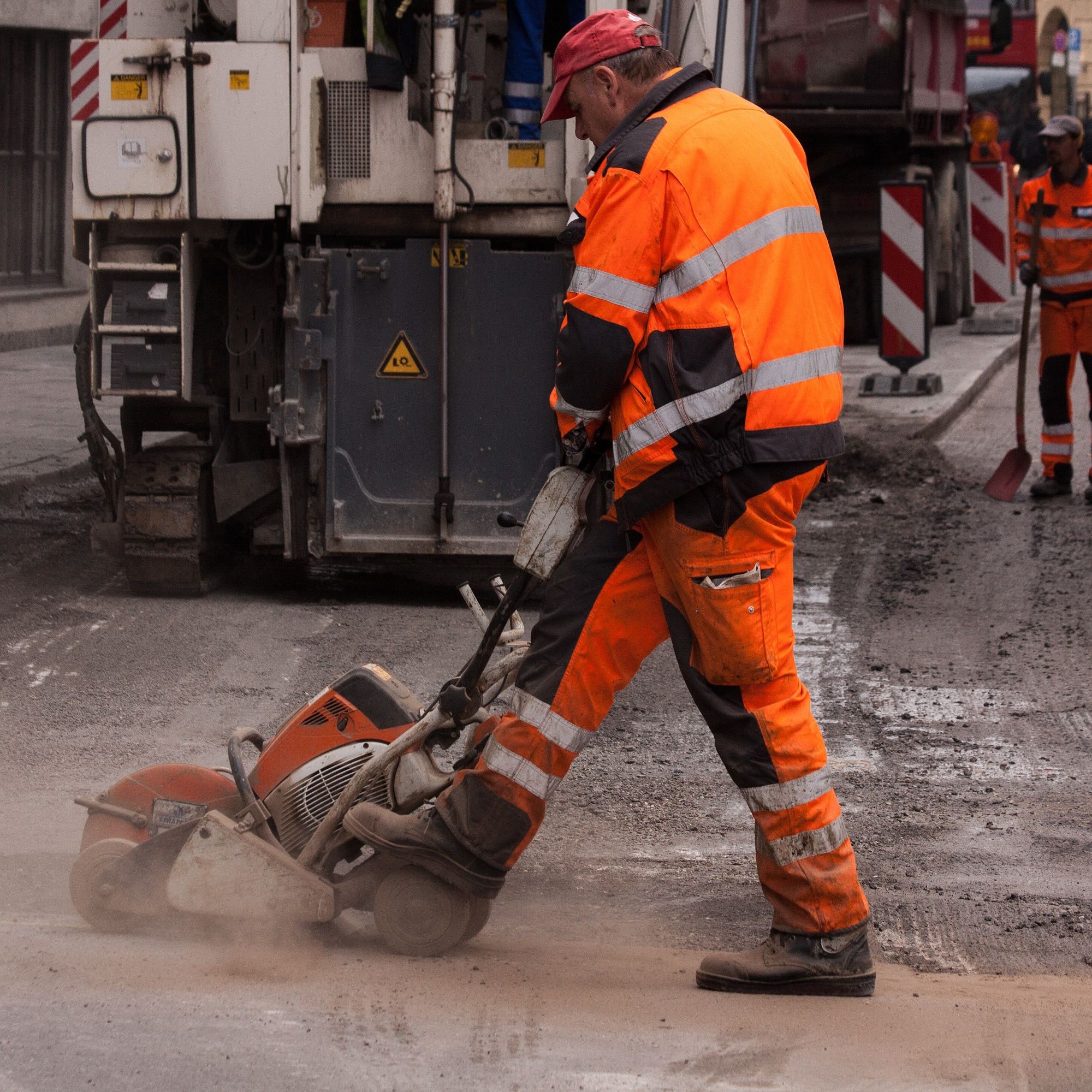 Strassenbau, Arbeiter mit Maschine