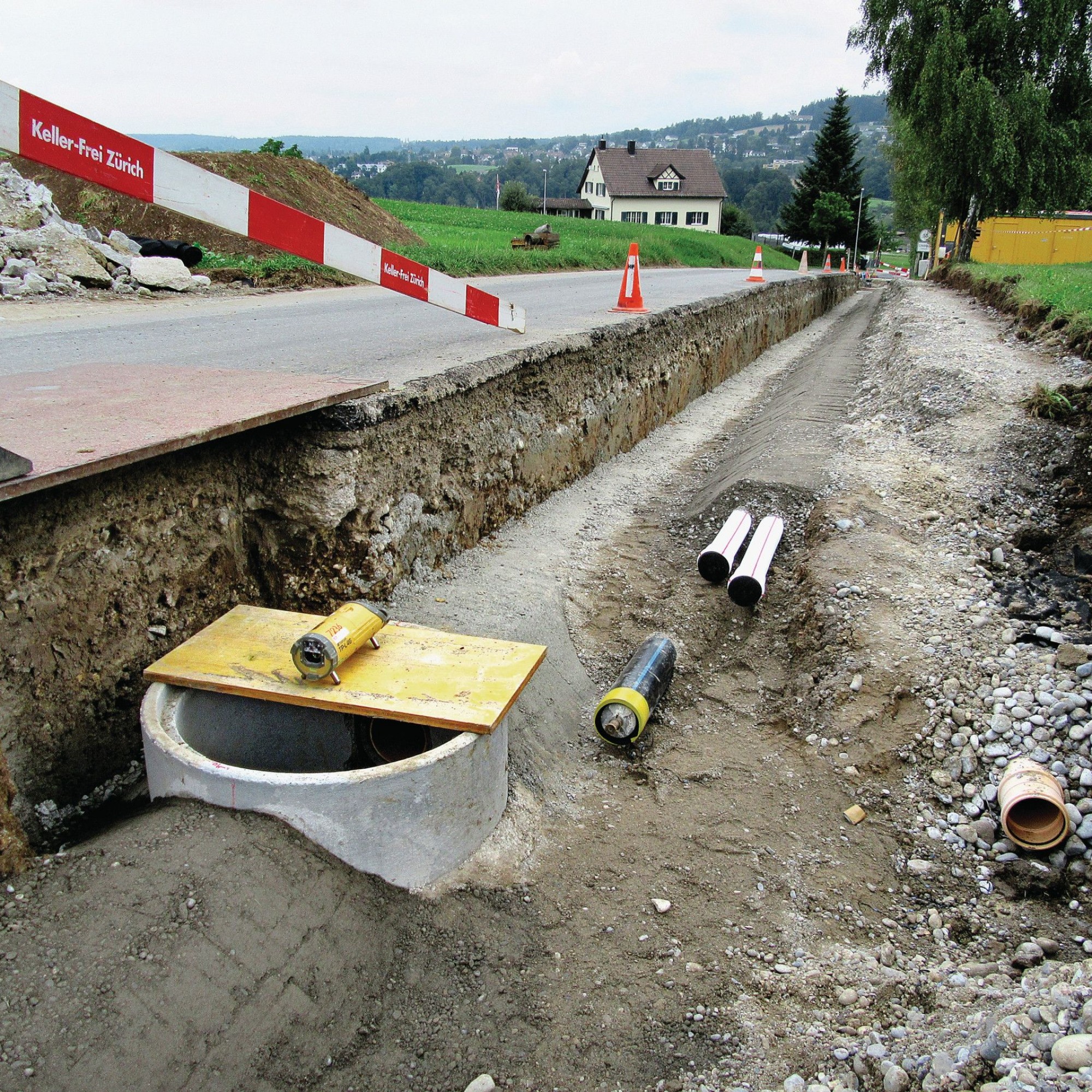 Graben mit Kanalisation, Sickerleitung, Elektrorohrblock und Wasserleitung