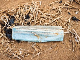 Weggeworfene Maske an einem Strand