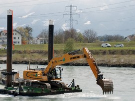 Bagger reisst Flusssohle im Alpenrhein auf.