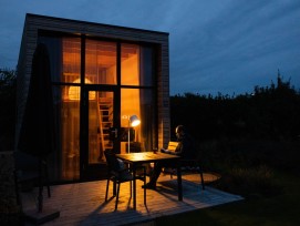 Tiny House mit Terrasse bei Nacht (Symbolbild)