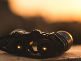 Fernglas vor goldenem Himmel