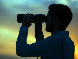Mann mit Fernglas im Gegenlicht