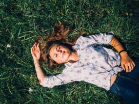 Schlafende Frau auf einer Wiese.