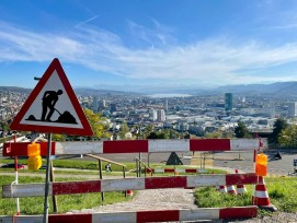 Baustellenschild und Ausblick auf Stadt Zürich