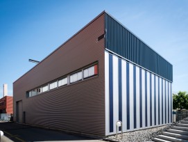 Die Halle auf dem Campus Horw mit dem perforierten Blech (schwarzer, oberer Teil der Fassade) an der Südseite. (Martin Vogel / HSLU)