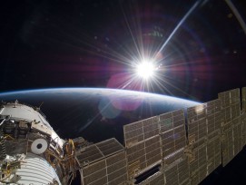 ISS über der Erde mit Sonne.