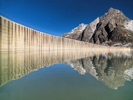 Lägh da l’Albigna GR: An einem wolkenlosen Herbsttag spiegelt sich die 1959 erbaute Schwergewichtsmauer im Bergeller Stausee.