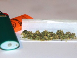 Cannabis in Zigarettenpapier mit Feuerzeug.