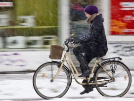 Frau fährt Velo im Schnee