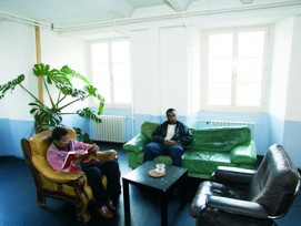 Zwei Asylsuchende sitzen auf dem Sofa in einem Bundeszentrum