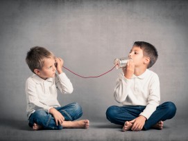 Kinder unterhalten sich mittels Dosen und Schnur